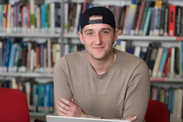 Der Bibliothek Männlicher Student Mit Schirmmütze Der Laptop Und Büchern — Stockfoto