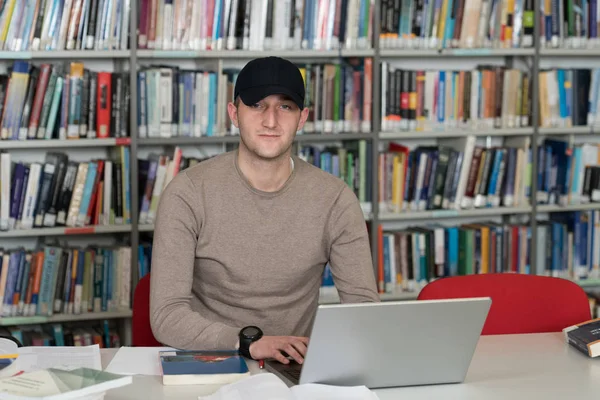 Φοιτητής Αρσενικό Βιβλιοθήκη Καπάκι Που Εργάζονται Για Laptop Και Βιβλία — Φωτογραφία Αρχείου