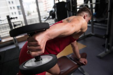 Modern Fitness Merkezi salonunda Dumbbells ile Triceps için yapıyor ağır egzersiz kas genç adam
