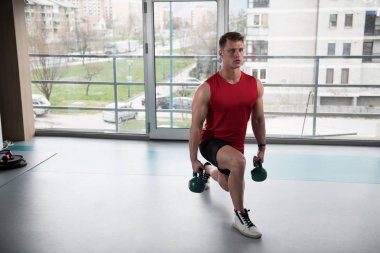 Genç adam su ısıtıcısı çan karanlık bir spor salonu - su ısıtıcısı-bell ile ağır egzersiz yapmak Bodybuilder olan çalışma dışarı