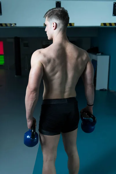 Junger Mann Trainiert Mit Wasserkocher Glocke Dunkler Turnhalle Bodybuilder Macht — Stockfoto