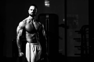 Elinde ağırlıkları olan genç bir adamın portresi.