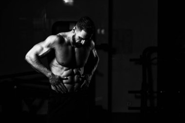 İyi eğitilmiş vücudunu gösteren genç bir adamın portresi - kaslı atletik vücut geliştirici spor sonrası vücut geliştirme modelliği pozu