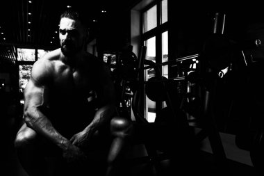 Yakışıklı ve çekici bir genç adam. Vücut kasları spor salonunda dinleniyor.