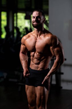 Spor Salonunda Güçlü Duran Genç Adam - Kas Atletik Vücut Geliştirici Spor Sonrası Spor Pozisyonu