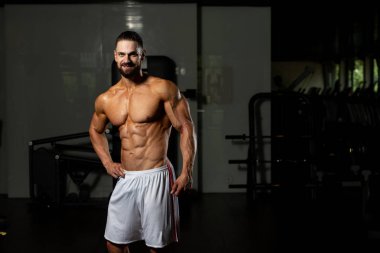 Spor Salonunda Güçlü Duran Genç Adam - Kas Atletik Vücut Geliştirici Spor Sonrası Spor Pozisyonu