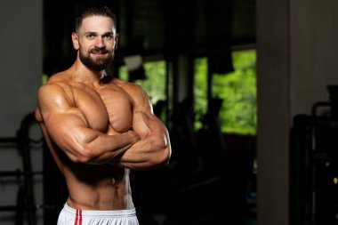 İyi eğitilmiş vücudunu gösteren genç bir adamın portresi - kaslı atletik vücut geliştirici spor sonrası vücut geliştirme modelliği pozu