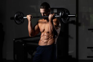 Spor salonunda bilardo oynayan sporcu halterle kıvrılıyor.