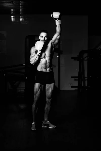 ボクシングについての映画のアイデア健康的なライフ スタイルのコンセプトのジムでボクシング 黄色のボクシング グローブでハンサムな男 — ストック写真