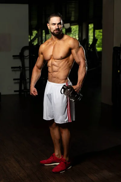 Muscular Man Resting After Exercise And Drinking From Shaker