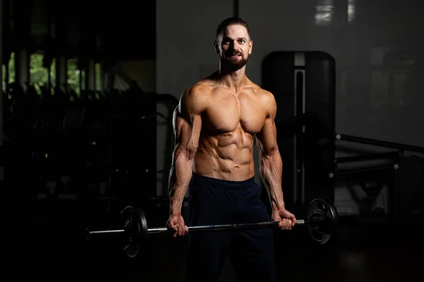 Svalnatý Muž Dělá Těžké Tělesné Cvičení Pro Biceps Činkou Tělocvičně — Stock fotografie