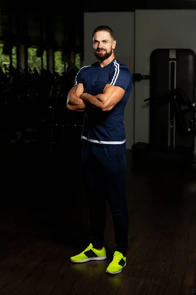 Portrait Of Personal Trainer In Sports Outfit In Fitness Center Gym Standing Strong