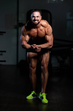 İyi eğitilmiş vücudunu gösteren genç bir adamın portresi - kaslı atletik vücut geliştirici spor sonrası vücut geliştirme modelliği pozu