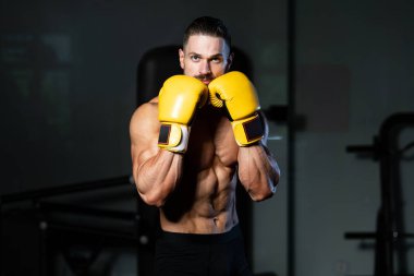 Yakışıklı adam sarı boks eldiven boks hakkında Film için fikir - sağlıklı bir yaşam tarzı kavramı - spor salonunda boks-