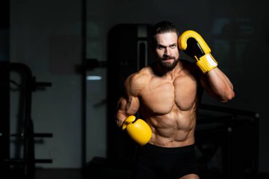 Yakışıklı adam sarı boks eldiven boks hakkında Film için fikir - sağlıklı bir yaşam tarzı kavramı - spor salonunda boks-