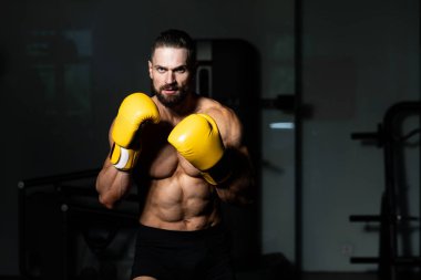 Yakışıklı adam sarı boks eldiven boks hakkında Film için fikir - sağlıklı bir yaşam tarzı kavramı - spor salonunda boks-