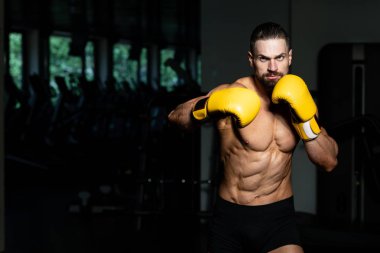 Yakışıklı adam sarı boks eldiven boks hakkında Film için fikir - sağlıklı bir yaşam tarzı kavramı - spor salonunda boks-