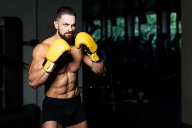 Yakışıklı adam sarı boks eldiven boks hakkında Film için fikir - sağlıklı bir yaşam tarzı kavramı - spor salonunda boks-