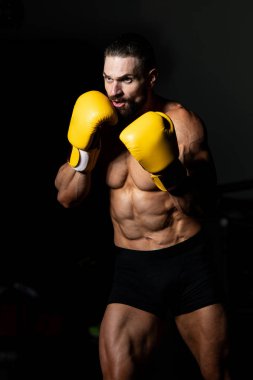Yakışıklı adam sarı boks eldiven boks hakkında Film için fikir - sağlıklı bir yaşam tarzı kavramı - spor salonunda boks-