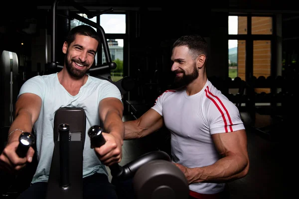 Personal Trainer Mostrando Jovem Como Treinar Volta Máquina Ginásio — Fotografia de Stock