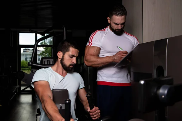 Personal Trainer Che Mostra Giovane Come Allenarsi Nuovo Macchina Palestra — Foto Stock