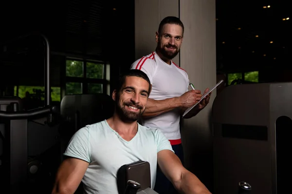 Personal Trainer Che Mostra Giovane Come Allenarsi Nuovo Macchina Palestra — Foto Stock