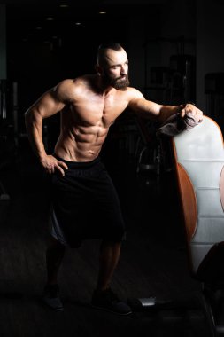 Yakışıklı ve çekici bir genç adam. Vücut kasları spor salonunda dinleniyor.