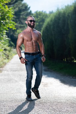 Yakışıklı Sakallı Adam Güçlü Duruyor ve Dışarda Pozisyon Veriyor Yaprakların Arkaplan Doğası