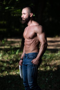 Onun iyi gösterilen pençeleri ile sağlıklı bir Wolverine portresi vücut - kaslı atletik vücut Fitness süper kahraman açık havada poz eğitimli
