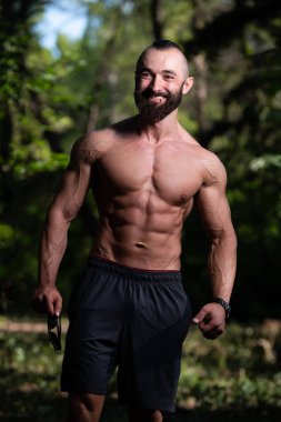 Yakışıklı Sakallı Adam Güçlü Duruyor ve Dışarda Pozisyon Veriyor Yaprakların Arkaplan Doğası