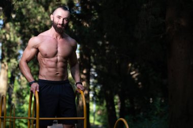 Genç bir portresi, fiziksel olarak gösterilen vücut - kaslı atletik vücut Fitness Model açık havada - bir yer, metniniz için poz onun iyi eğitimli adam uygun