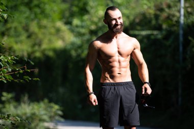 Yakışıklı Sakallı Adam Güçlü Duruyor ve Dışarda Pozisyon Veriyor Yaprakların Arkaplan Doğası