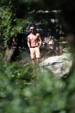 Genç bir portresi, fiziksel olarak gösterilen vücut - kaslı atletik vücut Fitness Model açık havada - bir yer, metniniz için poz onun iyi eğitimli adam uygun