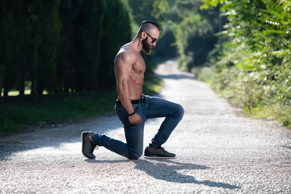 Handsome Young Model Kneeling Strong Outdoors Flexing Muscles Muscular Athletic — Stock Photo, Image