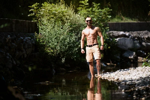 Kaslı atletik vücut Fitness Model açık havada poz ayakta güçlü kasları - esneme sağlıklı genç adam