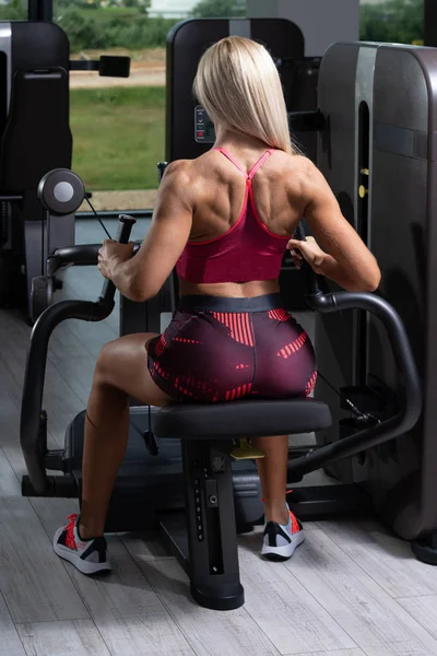 Kvinna Utövar Tillbaka Maskin Gymmet Och Flexar Muskler — Stockfoto