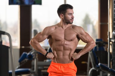 İyi eğitilmiş vücudunu gösteren genç bir adamın portresi - kaslı atletik vücut geliştirici spor sonrası vücut geliştirme modelliği pozu