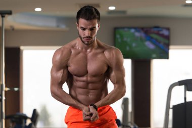 Yakışıklı Genç Adam Spor Salonunda Güçlü Duruyor ve Kaslarını Geriyor - Kas Atletik Vücut Geliştirici Spor Sonrası Spor Pozisyonu