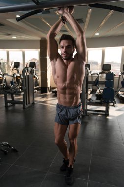 Spor salonu ve kasların esneme - güçlü ayakta sağlıklı genç adam kaslı atletik vücut Fitness Model çalışmaları sonra poz