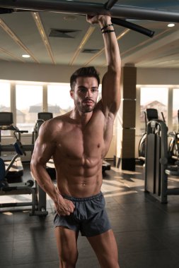 Yakışıklı Genç Adam Spor Salonunda Güçlü Duruyor ve Kaslarını Geriyor - Kas Atletik Vücut Geliştirici Spor Sonrası Spor Pozisyonu