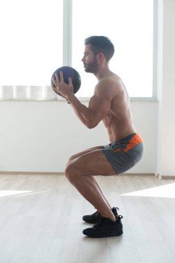 Yakışıklı genç adam kadrosu sağlık topu ile vücut geliştirme eğitim bir parçası olarak yapıyor