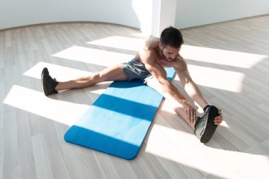 Katta bir spor salonu ve esneme kasları - kaslı atletik vücut Fitness modeli kaslı adam uzanır