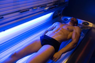 Solaryum güzellik salonları içinde genç kaslı adam
