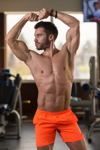 一个体格健壮的年轻人在训练后展现其训练有素的身体的画像 肌体健美模型在训练后的应用 — 图库照片