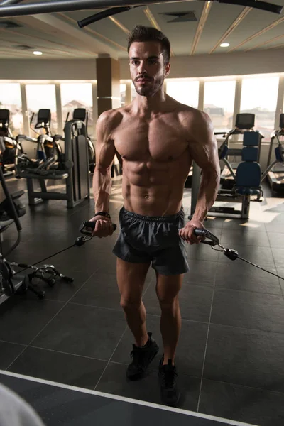 肌肉人做重的重量锻炼为胸口在机器与缆绳在健身房 — 图库照片