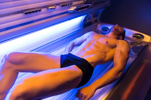 Young Muscular Man At Solarium In Beauty Salon