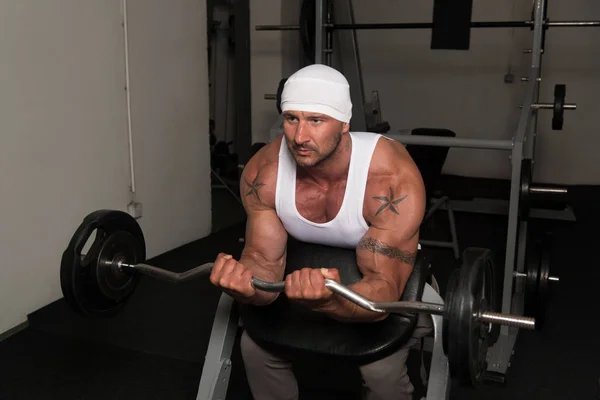 Muskularny Mężczyzna Robi Ciężkie Ćwiczenia Wagi Dla Biceps Sztangą Siłowni — Zdjęcie stockowe
