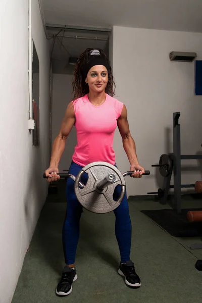 年轻女子回在机在健身房里锻炼和展示肌肉 肌肉运动健美健身模型 — 图库照片