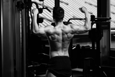 İyi eğitilmiş vücudunu gösteren genç bir adamın portresi - kaslı atletik vücut geliştirici spor sonrası vücut geliştirme modelliği pozu