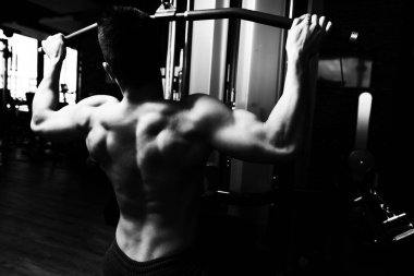 Yakışıklı Vücut Geliştirici Makineye Geri Dönmek İçin Ağır Ağırlık Egzersizi Yapıyor